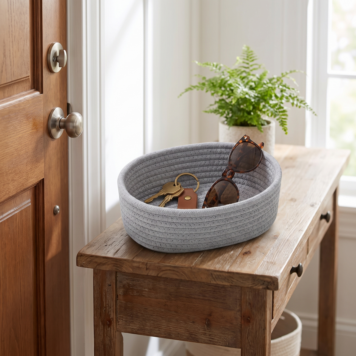 Grey cotton rope storage basket holding keys on a console table